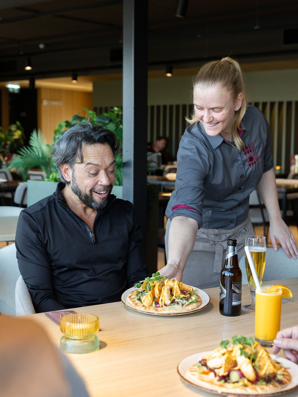Medewerker van DROOM! serveert een lunch aan een gast